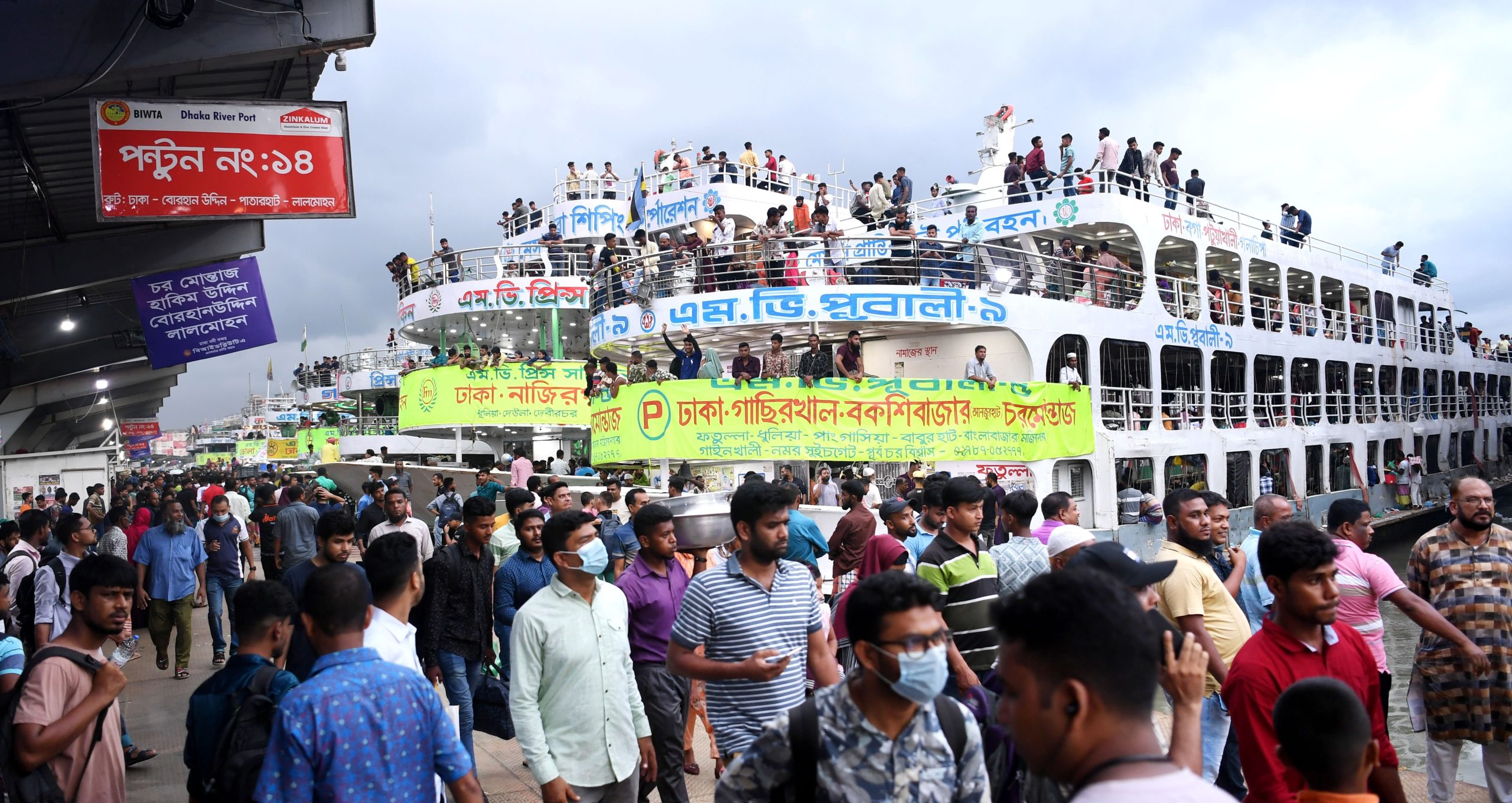 Crowds of Eid travellers boarding ferries at Sadarghat launch terminal in Dhaka.