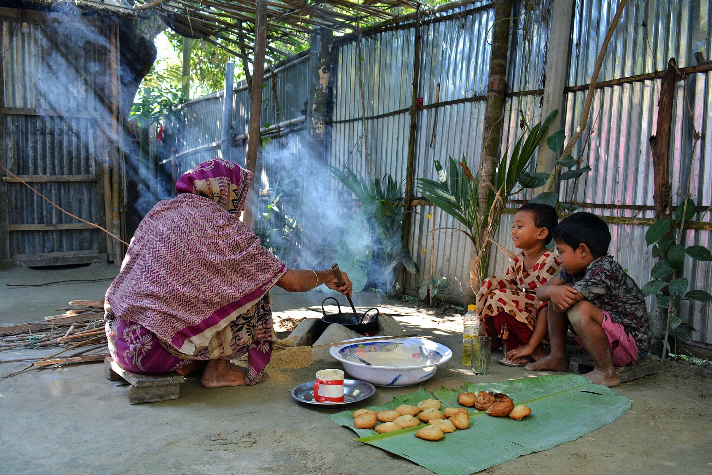 চুলায় রান্নারত একজন প্রবীণ নারী — প্রতীকী ছবি