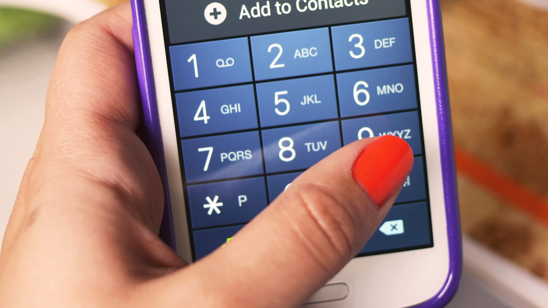 A hand dialling on a mobile phone keypad (symbolic image)